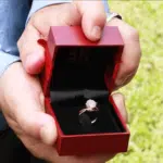 a person presenting solitaire engagement ring when proposing