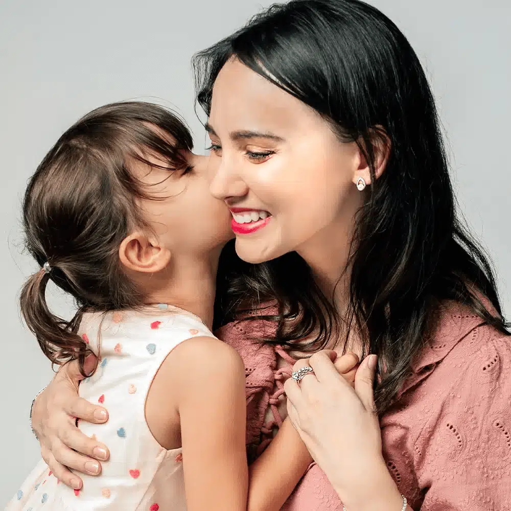 SK a mother wearing a rose gold diamond ring with a twirl shaped pave band in 18k white gold and rose gold and 101 facets lab grown diamond with her daughter